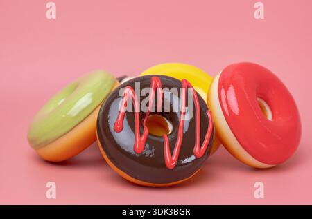Nahaufnahme glasierter Donuts auf rosa Hintergrund Stockfoto