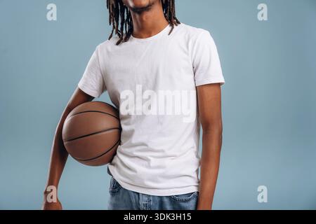 Basketballspieler. Schwarzer Mann ist im Studio vor weichem Hintergrund. Stockfoto