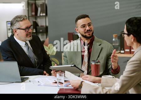 Multiethnische Young Adult Professionals diskutieren Geschäftsstrategie im Büro Stockfoto