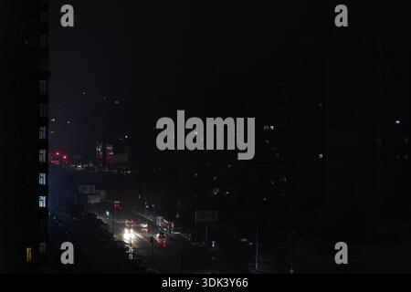 Kiew, Ukraine – 28. Januar 2026: Totale Dunkelheit in Kiew Wohngebiet bei Nacht. Dunkle Stadtstraße mit seltenen Autoscheinwerfern während eines Stromausfalls verursacht b Stockfoto