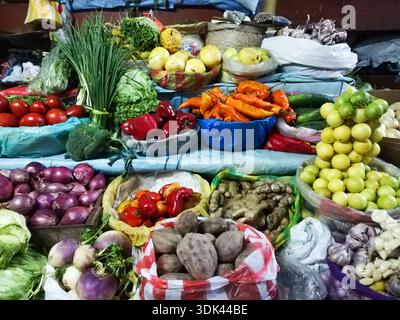 Ein Tisch voller Gemüse und Obst. Es gibt viele verschiedene Arten von Gemüse und Obst, einschließlich Tomaten, Paprika, Kartoffeln und Zwiebeln Stockfoto