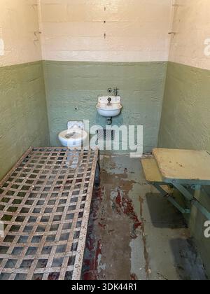 Innenraum der ehemaligen Gefängniszelle mit Metallbettrahmen und Waschbecken auf Alcatraz Island, Kalifornien, USA. Stockfoto
