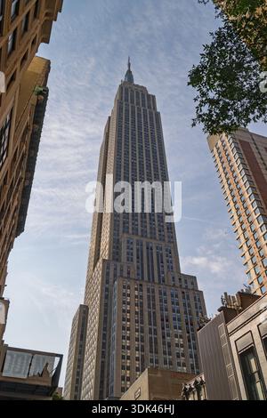 Das Sonnenlicht blickt auf den riesigen Kalkstein des Empire State Building, ein stiller Riese, der über die Straßen von New York City wacht. Eingerahmt von der Tat Stockfoto
