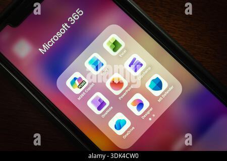 Nahaufnahme eines Smartphones mit dem Microsoft 365-Ordner mit Apps wie Word, Excel, PowerPoint, OneDrive und Copilot. Stockfoto