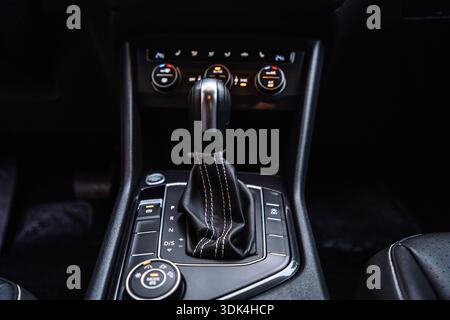 Nahaufnahme eines automatischen Autoschalthebels im modernen Fahrzeuginnenraum. Fahrzeugcockpit-Detail mit Getriebesteuerung, Premium-Ma Stockfoto