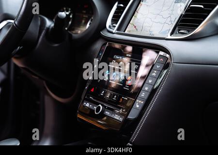 Nahaufnahme eines Infotainment-Touchscreens mit Navigationskarte und Steuerungsmenü. Moderne Details im Fahrzeuginnenraum, die die digitale Schnittstelle hervorheben Stockfoto