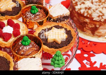 Verschiedene Weihnachtsgebäck auf festlichem Tisch. Traditionelle Mohnkuchen und Weihnachtsdesserts. Hausgemachte Süßigkeiten für Winterfeiern und Familien. Stockfoto