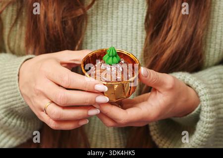Frau, die heiße Schokoladen-Dessert-Nahaufnahme hält. Süße hausgemachte Leckereien und gemütliche Winterjause in der kalten Jahreszeit. Stockfoto