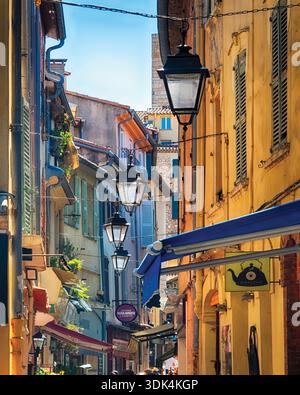 Hausfassaden einer charmanten Straße mit pastellfarbenen Häusern und hängenden Straßenlaternen, Antibes, Alpes Maritimes, Cote D'Azur, französische Riviera, F Stockfoto