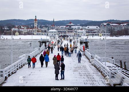 Winterszene am Sopot Pier mit Leuten, die über den schneebedeckten Holzpier laufen, Ostseeküste, Sopot, Polen. Stockfoto