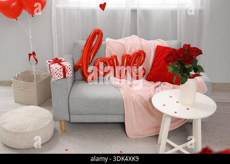 Word LOVE gemacht mit Ballon auf Sofa im Wohnzimmer dekoriert zum Valentinstag Stockfoto