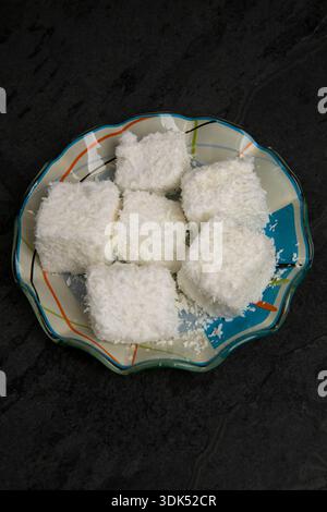 Typisch brasilianische Süßigkeit namens Maria-Mole, eine Art weicherer Marshmallow, auf schwarzem Hintergrund Stockfoto