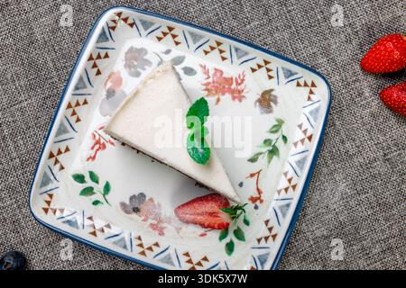 Exquisites, helles und luftiges mehrlagiges Dessert mit „drei Pralinen“ auf einem weißen Teller. Eine vertikale Nahaufnahme zeigt die zarte Textur Stockfoto