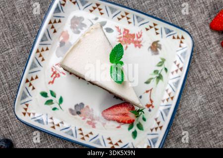 Exquisites, helles und luftiges mehrlagiges Dessert mit „drei Pralinen“ auf einem weißen Teller. Eine vertikale Nahaufnahme zeigt die zarte Textur Stockfoto