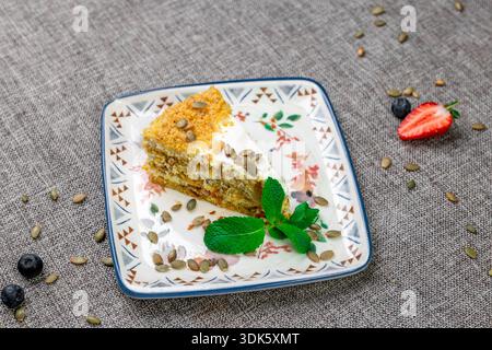 Aromatischer, mehrschichtiger hausgemachter Kürbiskuchen. Vertikale Nahaufnahme mit der Textur von Kürbisschichten, einer zarten cremigen oder sauren Cremefüllung, Stockfoto