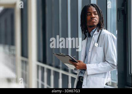 Seitenansicht. Der junge schwarze Doktor ist auf dem Flur. Stockfoto