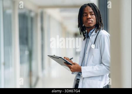 Seitenansicht. Der junge schwarze Doktor ist auf dem Flur. Stockfoto