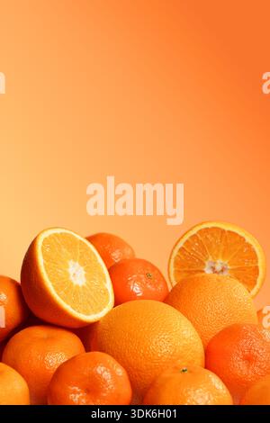 Frische Orangen und Mandarinen auf orangefarbenem Hintergrund. Stockfoto