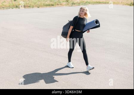 Frau mit Yogamatte und Sporttasche Stockfoto