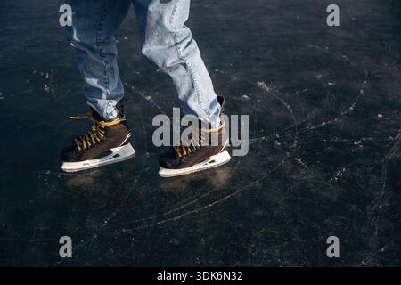 Nahaufnahme eines Mannes, der im Winter mit Schlittschuhen auf Eis ist. Stockfoto