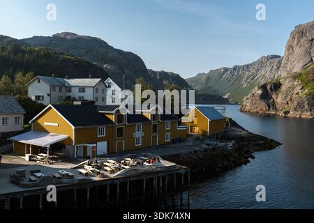 Blick auf das Fischerdorf Nusfjord in Flakstad, Lofoten Inseln, Norwegen, bei Sonnenuntergang, mit traditionellen Gebäuden und einer friedlichen Atmosphäre Stockfoto