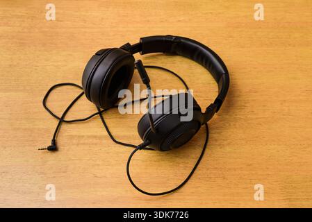 Schwarzes Gaming-Headset mit Mikrofon auf dem Tisch, Draufsicht. Stockfoto