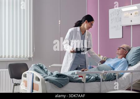 Asiatische Ärztin Mittleren Alters Beratender Senior Männlicher Patient Stockfoto