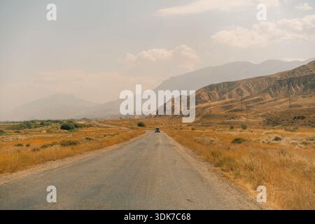 Eine unbefestigte Straße, die durch eine trockene, hügelige Landschaft führt. Hochwertige Fotos Stockfoto
