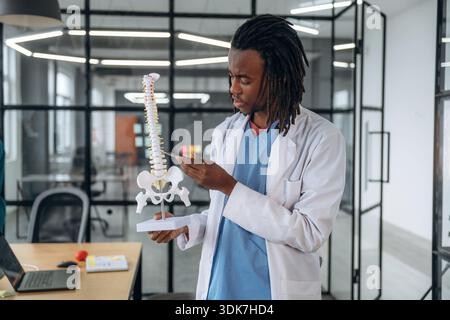 Man Doctor zeigt das Modell der menschlichen Wirbelsäule. Stockfoto