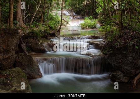 Die Kaskadierung der Erawan-Wasserfälle im Erawan-Nationalpark, Thailand. Üppig grüner Wald umgeben von gestuften Wasserfällen. Stockfoto