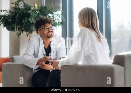 Sitzen und reden. Mann und Frau sind drinnen in einem modernen Gebäude. Stockfoto