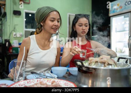 Freunde genießen das thailändische bbq-Abendessen mit Mookata Stockfoto