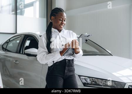 Autoverkäufer, Geschäftsfrau steht im Automobilsalon. Stockfoto