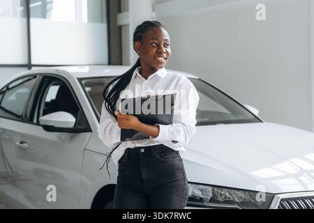 Autoverkäufer, Geschäftsfrau steht im Automobilsalon. Stockfoto