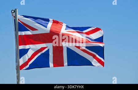 Die Union Jack-Flagge weht im Wind gegen einen klaren blauen Himmel. Lancashire, Großbritannien. Stockfoto