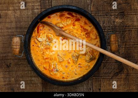 Fischeintopf oder Moqueca de Peixe auf Portugiesisch, typisch brasilianisches Gericht, in einem Tontopf auf schwarzem Stein. Sao Paulo, Brasilien Stockfoto