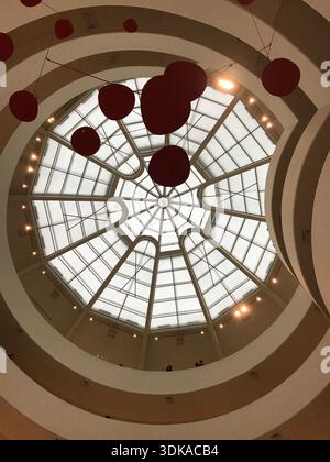 Moderne Museumsatriumdecke mit kreisförmigem Oberlicht, hängenden roten Kugeln, geometrischer Architektur und dramatischem Blick auf das Innere Stockfoto