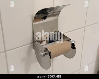 Leerer Toilettenpapierhalter mit Kartonrollen im modernen gefliesten Badezimmer Stockfoto