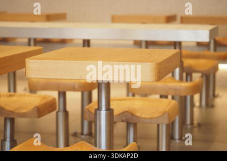 Holztische in einem Essbereich mit Metallstützen Stockfoto