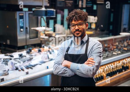 Männlicher Arbeiter ist im Supermarkt. Stockfoto