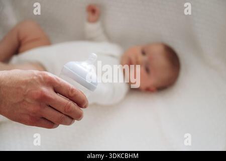 Halten der Flasche. Nahaufnahme der Mutter und des kleinen Babys. Stockfoto