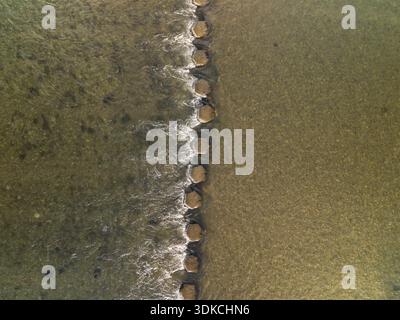 Von oben nach unten blickende Steine in einem flachen Fluss. Stockfoto