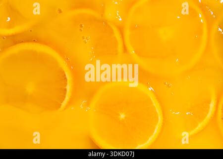 Abstrakter Hintergrund der mit Saft bedeckten Orangenscheiben Stockfoto