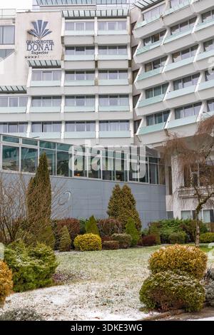 ROGASKA SLATINA, SLOWENIEN, 01.03.2026: Moderner Hotelkomplex mit Glaswänden, getrimmten Evergreens und frostgetöntem Rasen. Das Grand Hotel Don Stockfoto