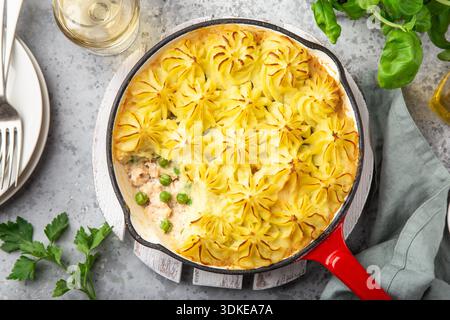 Lachs-Hirtenkuchen. Fisch in cremiger Sauce, Kartoffelpüree und Gemüseauflauf in Emaille-Gusseisenpfanne. Draufsicht Stockfoto