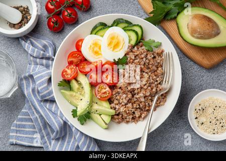 Gesunde vegane Lunch Bowl mit Avocado, Ei, Gurke, Tomate und Buchweizen, Draufsicht Stockfoto