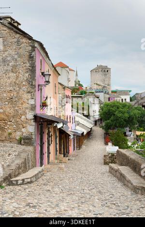 Mostar, Bosnien und Herzegowina – 1. Juni 2020: Kopfsteinpflasterstraße mit traditionellen Steinhäusern in der historischen Altstadt von Mostar. Stockfoto