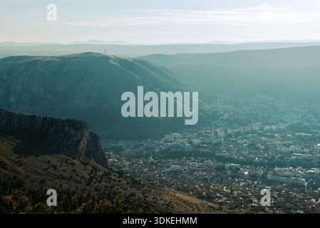 Weite Landschaft mit Blick auf Mostar und das Neretva-Tal, Blick auf Berge, städtisches Gebiet und natürliches Gelände unter ruhigen atmosphärischen Bedingungen. Stockfoto