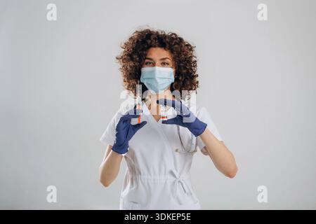 In der Schutzmaske. Die schöne Ärztin ist im Studio. Stockfoto