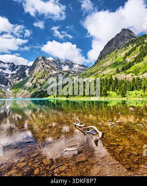 Wunderschöner Hochgebirgssee Verkhnemultinskoje zwischen schneebedeckten Gipfeln und Wäldern im russischen Altai-Gebirge Stockfoto